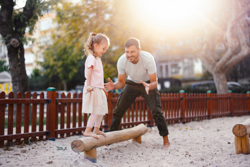 Parent supervising child on play equipment